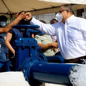 pozo agua potable dos funcionarios hombres chocan puños