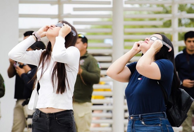 Dos adolescentes mujeres con lentes para ver el eclipse