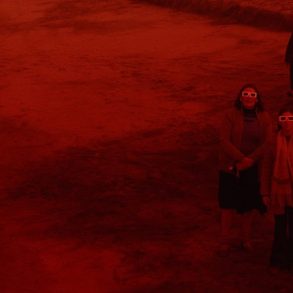 Personas observando un eclipse en escena de la película Rojo de Benjamin Naishtat