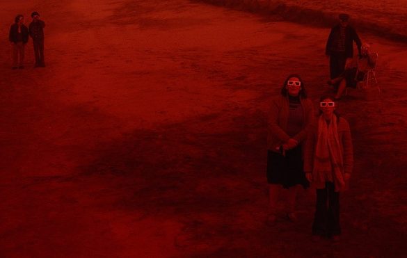 Personas observando un eclipse en escena de la película Rojo de Benjamin Naishtat