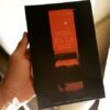 UNA MANO SOSTIENE EL LIBRO 'ROJA ES LA LUZ' DE CARLOS CASTAÑÓN